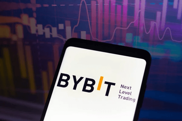 Bybit logo displayed on a smartphone screen with a financial chart in the background, representing cryptocurrency trading and exchange activity