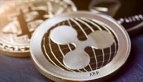 Physical coin with the XRP cryptocurrency logo highlighted, with Bitcoin and Ethereum symbols blurred in the background.