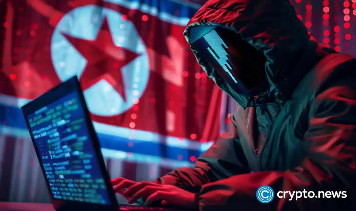 Hooded hacker in front of North Korean flag uses laptop with codes suggesting cyber attacks linked to the regime.